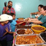Mayordoma de fiestas patronales reparte comida en la vela del barco en San Judas